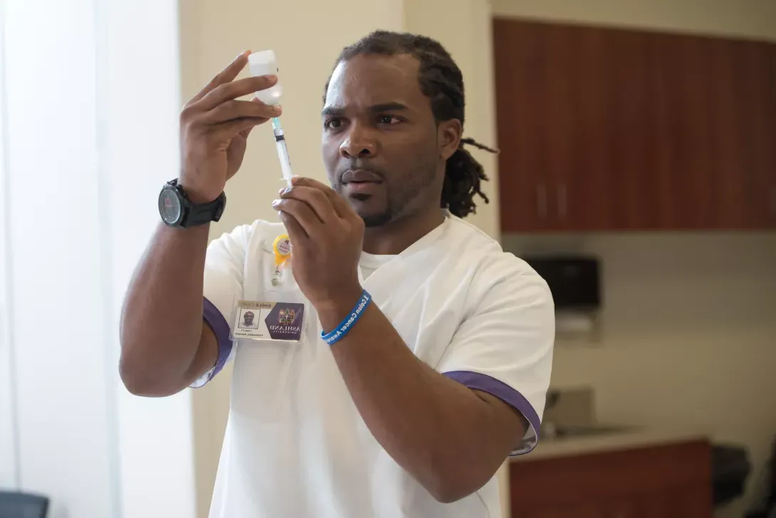 Male nursing student filling a. syringe